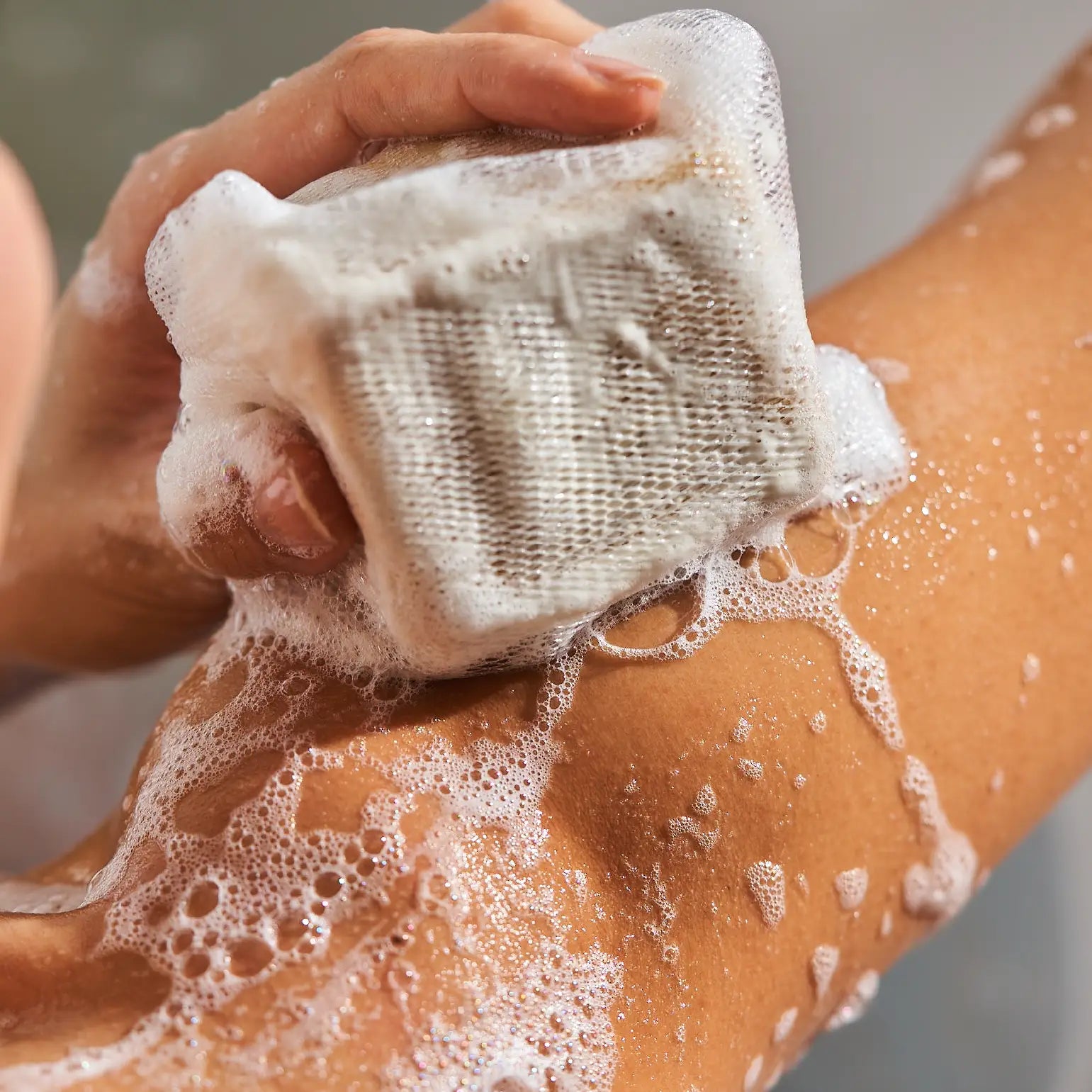 Lathering a natural aleppo soap bar to cleanse and soothe sensitive skin.